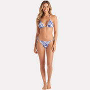 Mujer de pie en exterior usando bikini triángulo azul estampado, vista frontal.