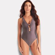 Mujer usando traje de baño entero color malva con escote en V y detalle frontal.