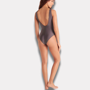 Mujer de pie mostrando parte trasera del traje de baño malva.