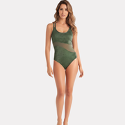 Mujer con traje de baño verde asimétrico sentada sobre piso de cerámica decorativa, vista superior.